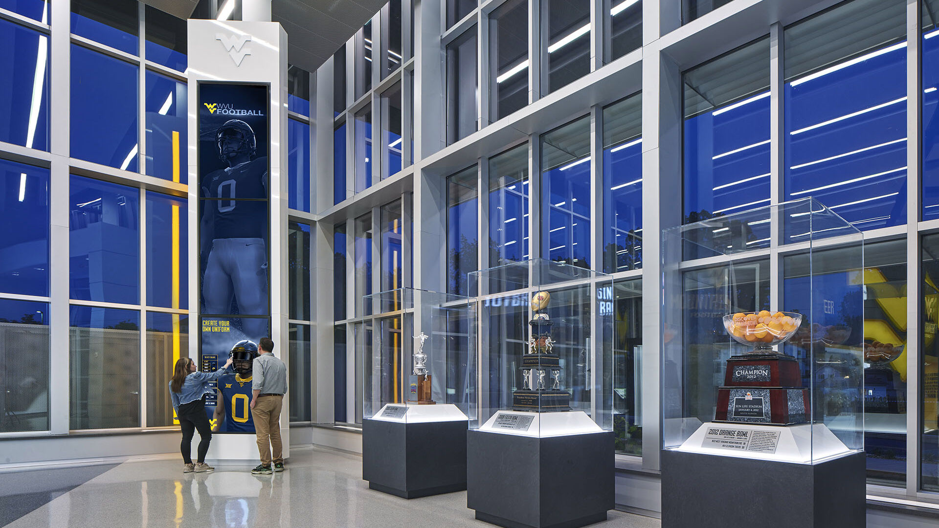 Man and woman use digital interactive display at the West Virginia Football Hall of Traditions