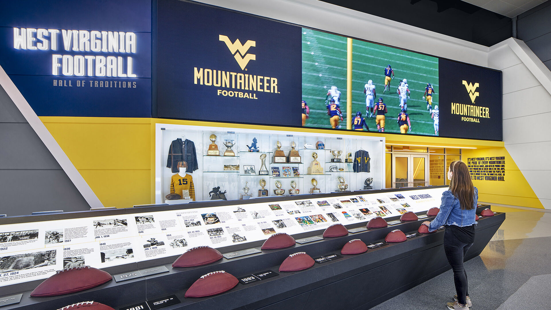 Woman uses the touch football interactive exhibit at the West Virginia Football Hall of Traditions