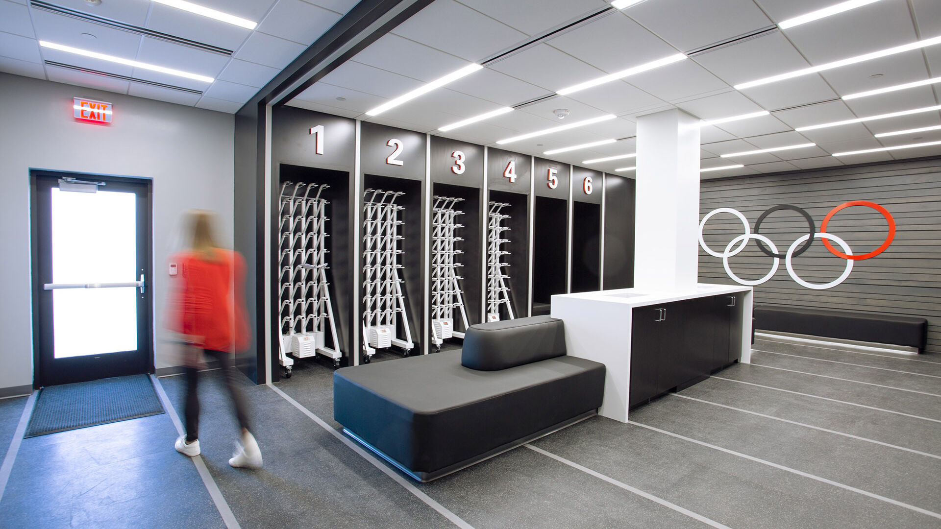 Woman walking through the University of Georgia Track and Field Mudroom with Olympic Rings Logo